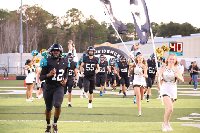 football players running through tunnel